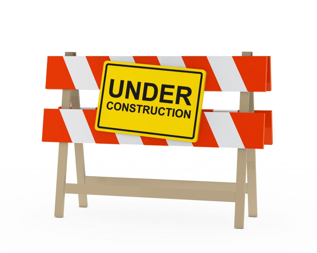 Orange and white barricade with a yellow “Under construction” sign